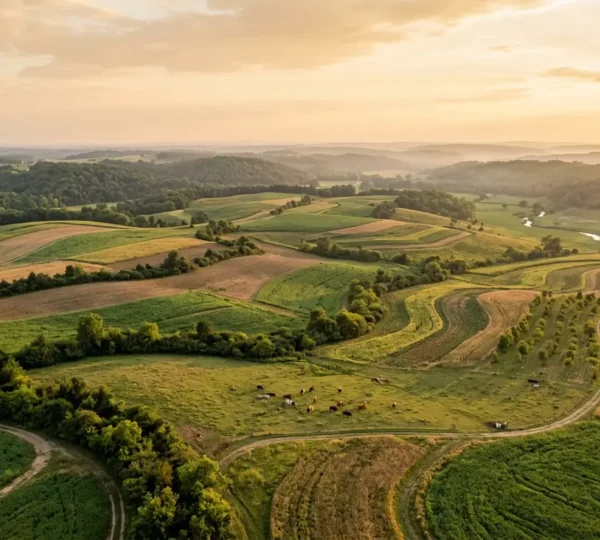 Aerial view of regenerative farm with diverse crop rotation, cover crops, and integrated livestock creating a closed-loop carbon sequestration system