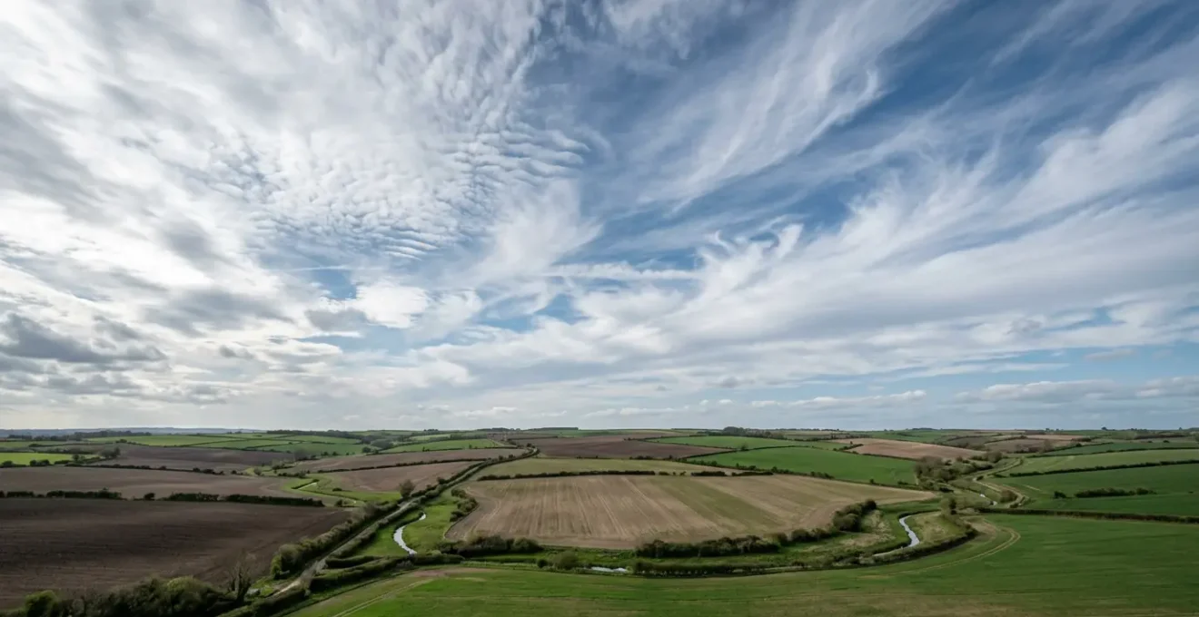 Atmospheric dynamics over UK farmland showing variable spring weather patterns