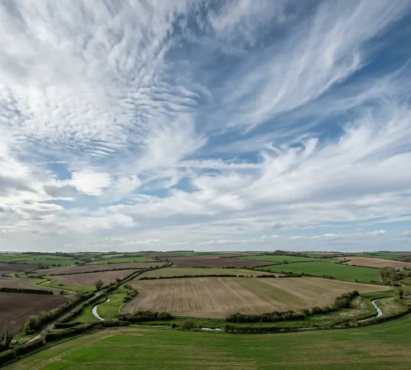 Atmospheric dynamics over UK farmland showing variable spring weather patterns